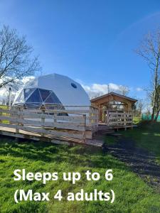 a dome tent on a fence next to a house at Little River Glamping in Ballymoney
