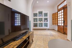 een grote woonkamer met een flatscreen-tv bij Charming & Cosy 2BR home with WIFI in Birgu by 360 Estates in Birgu