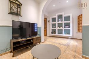 ein Wohnzimmer mit einem großen Flachbild-TV in der Unterkunft Charming & Cosy 2BR home with WIFI in Birgu by 360 Estates in Vittoriosa