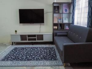 Il comprend un salon doté d'un canapé et d'une télévision à écran plat. dans l'établissement MGH Homestay Bangi Wonderland, à Kajang