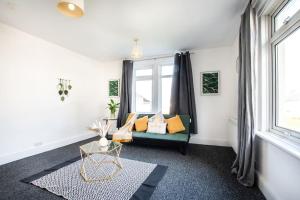 a living room with a green couch and a window at A cosy 2 bed flat in Swindon in Swindon