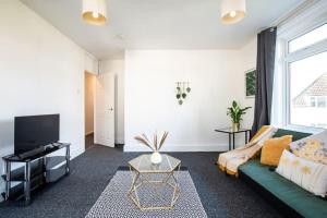 un soggiorno con divano verde e TV di A cosy 2 bed flat in Swindon a Swindon