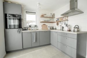 a kitchen with stainless steel appliances and white walls at Bungalow 68 op Recreatiepark De Wielen in Sint Maarten