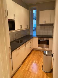 a kitchen with white cabinets and a trash can at Lovely apartment in Bergen in Bergen