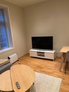 a living room with a flat screen tv and a table at Lovely apartment in Bergen in Bergen