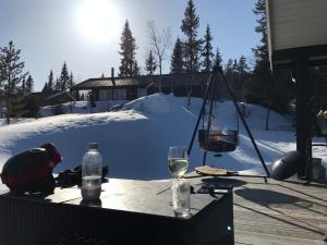 einen Tisch mit Weingläsern und eine Schaukel im Schnee in der Unterkunft Hytta for 8 personer skiut/inn in Trysil