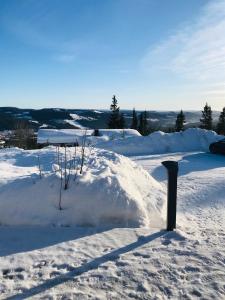 ein Schneehaufen mit einem Schild in der Mitte in der Unterkunft Hytta for 8 personer skiut/inn in Trysil