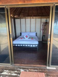 een bed in een afgeschermde veranda met een bedkap bij Sunset Beach Bungalow Koh Pu in Ko Jum