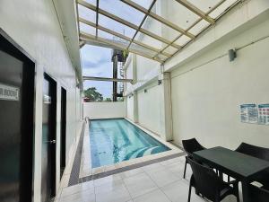 a swimming pool in a building with a table and chairs at Studio Casa Mira Tower 2 in Cebu City