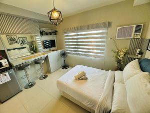 Studio Casa Mira Tower 2 في مدينة سيبو: غرفة نوم فيها سرير ومكتب