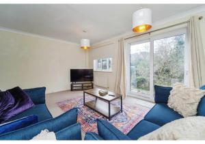 sala de estar con sofá azul y mesa en Charming Uxbridge 3BR Home with Parking en Uxbridge