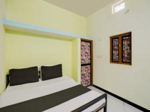 a bedroom with a bed and a window at SPOT ON Hotel Ik Recedency in Chandrapur