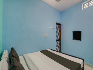 a bedroom with a bed with a blue wall at SPOT ON Hotel Ik Recedency in Chandrapur