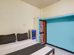 a bedroom with a bed and an air conditioner at SPOT ON Hotel Ik Recedency in Chandrapur