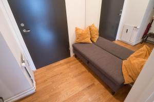 a couch in a small room with a wooden floor at Cosy Apartment in Frogner in Oslo