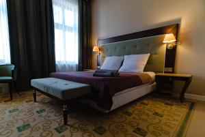 a hotel room with a bed and a chair at DK Dyplomat in Olsztyn