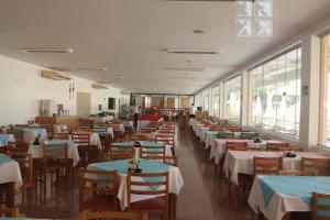 卡达斯诺瓦斯Apto 1 Suíte TOP - Pq aquático 24hs DiRoma Fiori的餐厅里有桌椅和窗户。