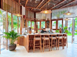 a man sitting at a bar in a restaurant at Le VIVA Resort Mui Ne in Mui Ne