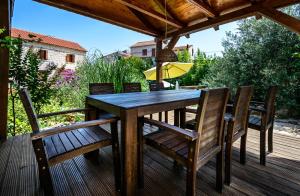 a wooden table and chairs on a deck at Vila Donna Apartments in Trogir