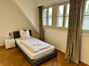 a small bed in a room with a window at Exklusives Apartment mit einmaligem Blick zur Frauenkirche - Parkplatz kostenfrei in Dresden