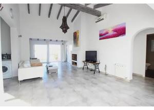 Verano في بينيسا: غرفة معيشة مع أريكة بيضاء وتلفزيون