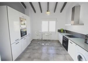 a kitchen with white cabinets and white appliances at Verano in Benissa