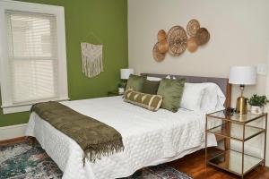 a bedroom with a large white bed with green walls at Downtown Gem 5 Min To City, Near Marta & Pullman in Atlanta