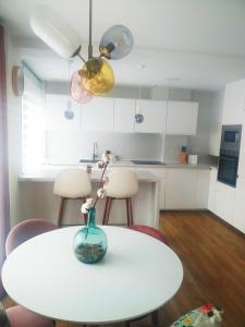 a white table with a vase on top of it at EL DESCANSO DE CARBAYEDO in Avilés