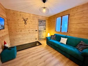 a living room with a blue couch and wooden walls at Leva des neiges in Lanslevillard