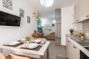uma cozinha e sala de estar com mesa e cadeiras em KELIFOS Comfort Apartment em SantʼAgata di Militello