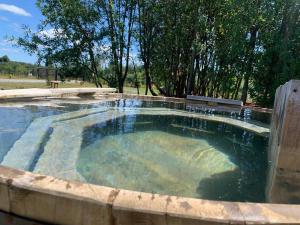 una gran piscina de agua con un banco. en Casa por día en Puerto Varas en Puerto Varas