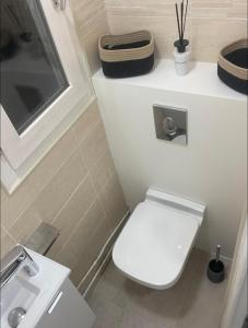 La petite salle de bains est pourvue de toilettes et d'un lavabo. dans l'établissement Eiffel Tour - Cosy Parisien, à Paris