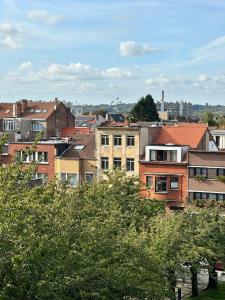 un groupe de bâtiments dans une ville arborée dans l'établissement Appartement une chambre moderne avec vue imprenable sur le parc et immense terrasse - Idéal pour une escapade urbaine!, à Bruxelles