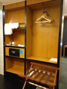 a wooden cabinet with a bench in a room at Aloft Bengaluru Whitefield in Bangalore