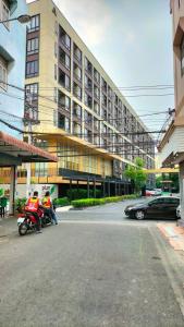 two people on motorcycles parked in front of a building at 1 Bed Room Near Saphanmai BTS, Don Mueang Airport in Ban Ko