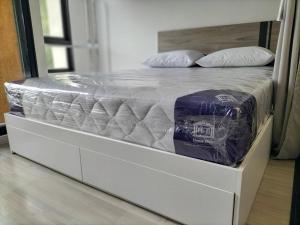 a white bed with a mattress wrapped in plastic at 1 Bed Room Near Saphanmai BTS, Don Mueang Airport in Ban Ko