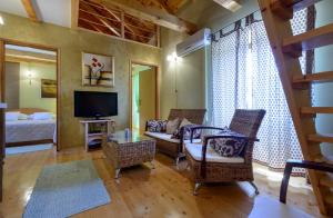a living room with a couch and chairs and a television at Vila Donna Apartments in Trogir