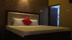 1 dormitorio con 1 cama con 2 almohadas rojas en Divine sparrow family homestay, en Agra