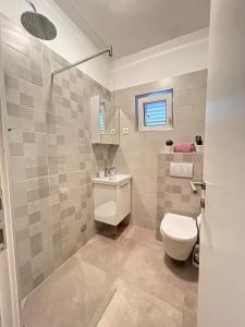 a bathroom with a toilet and a sink and a shower at Apartment Luka in Ivan Dolac