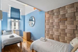 um quarto com 2 camas e uma parede azul em Modern Flat on The Hoe w Private Parking em Plymouth