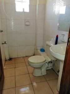a bathroom with a toilet and a sink at Klimax Place in Kiambu