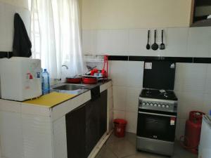 a small kitchen with a sink and a stove at Klimax Place in Kiambu