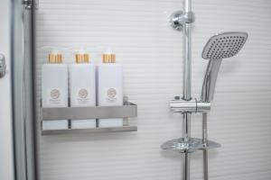 uma cabina de duche com duas garrafas de sabão e um banco em KELIFOS Comfort Apartment em SantʼAgata di Militello