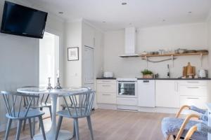 cocina con mesa y sillas y TV en Lägenhet med vacker havsutsikt, en Visby