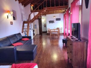 a living room with a couch and a tv at Casas da Biquinha in Sintra
