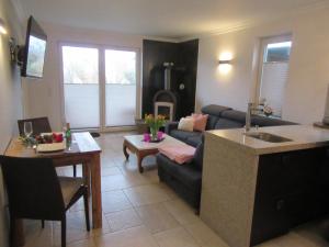a kitchen and living room with a couch and a table at Ferienwohnung Strand EG in Fehmarn