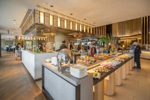 Crowne Plaza Bangkok Lumpini Park, an IHG Hotel في بانكوك: مطعم طابور البوفيه مع الطعام المعروض