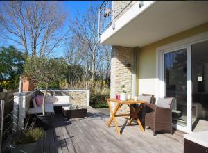 a patio with a table and chairs on a porch at Ferienwohnung Strand EG in Fehmarn
