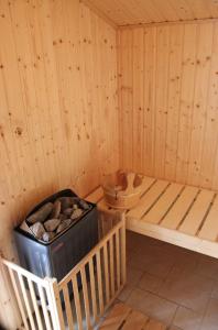 a corner of a wooden sauna with a trash can at Ferienwohnung Strand EG in Fehmarn