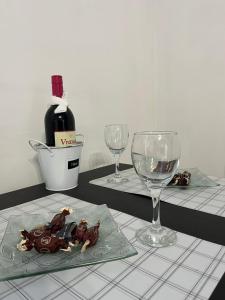 a table with two glasses and a bottle of wine at Nanny in Novi Sad